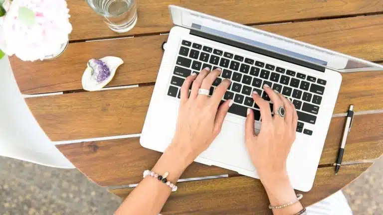 A woman's hands rest on a MacBook Pro