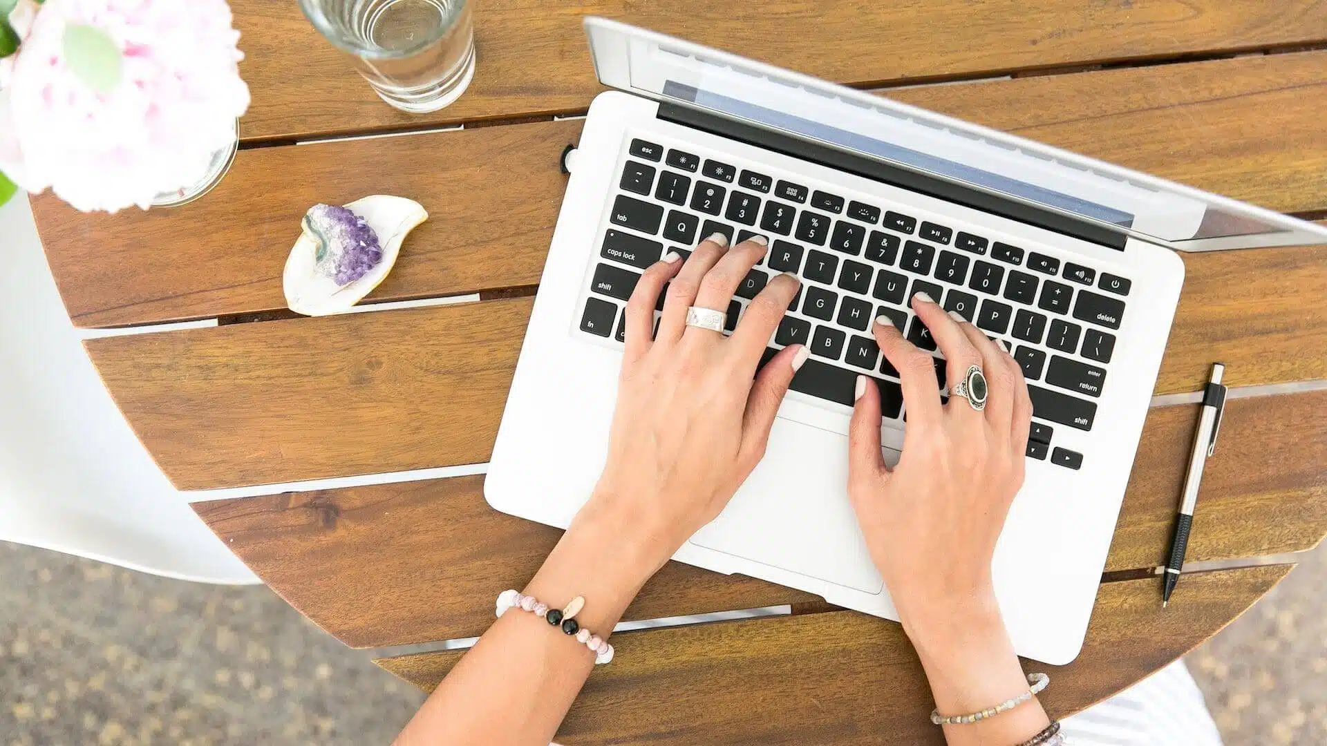 A woman's hands rest on a MacBook Pro